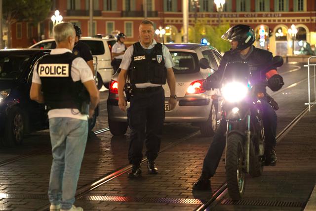 Police officers seal off the area of an attack after a truck drove on to the sidewalk and plowed through a crowd of in Nice last Friday