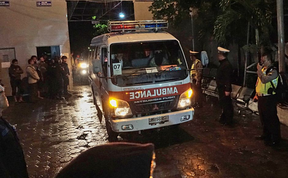 Police officers stand guard as a convoy of ambulances carrying the bodies of the four drug traffickers executed on Friday drives past. Pic AP