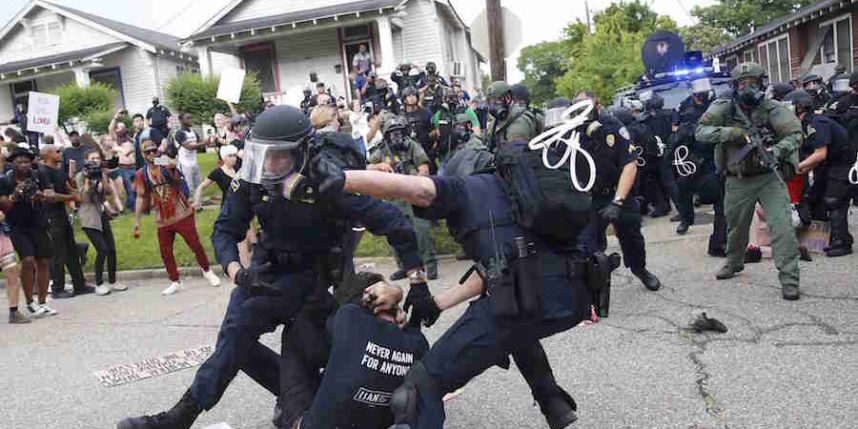 Police scuffle with a demonstrator as they try to apprehend him during a rally in Baton Rouge Louisiana