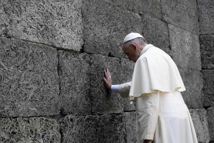 Pope Francis prays in front of the death wall at Auschwitz on Friday