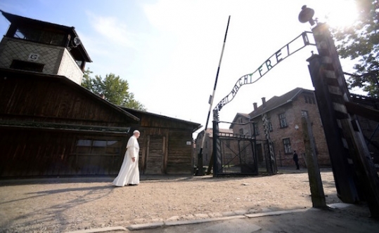 Pope Francis walks through Auschwitz's notorious gate with the sign'Arbeit Macht Frei during his visit to the former Nazi death camp in Poland on July 29