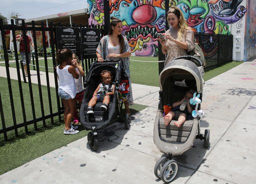 Vanessa Gomez 33 left with her son Ezra 2 and her friend Cristy Fernandez 33 with her 9-month-old son River of Miami walk in the Wynwood neighborhood of Miami Friday