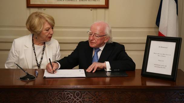 President Michael D Higgins and his wife Sabina sign the book of condolences at the Mansion House in Dublin