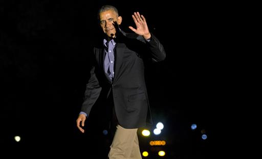 President Barack Obama waves on his return from a shortened visit to Spain as he walks across the South Lawn of the White House in Washington Sunday