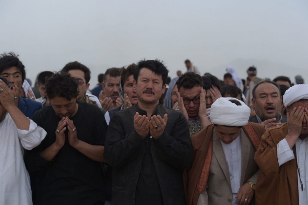 Afghan mourners offer funeral prayers for the 80 victims killed in a twin suicide attack in Kabul on Sunday