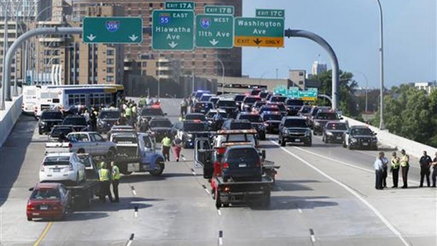 State troopers and police clear the Interstate 35W freeway where protesters blocked the highway leading into Minneapolis over the Mississippi River bridge during rush hour Wednesday