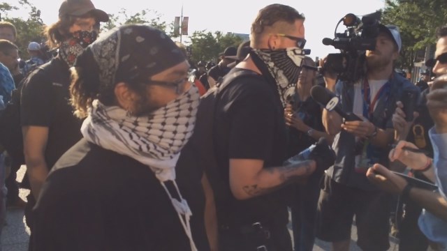 Protesters cover their faces during RNC