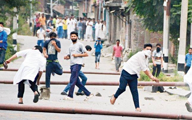 Protesters throw stones at security personnel who respond with tear-gas shells on Thursday at Srinagar