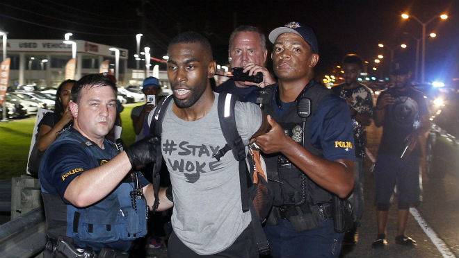 Police arrest activist De Ray McKesson during a protest along Airline Highway a major road that passes in front of the Baton Rouge Police Department headquarters in Baton Rouge La. on Saturday