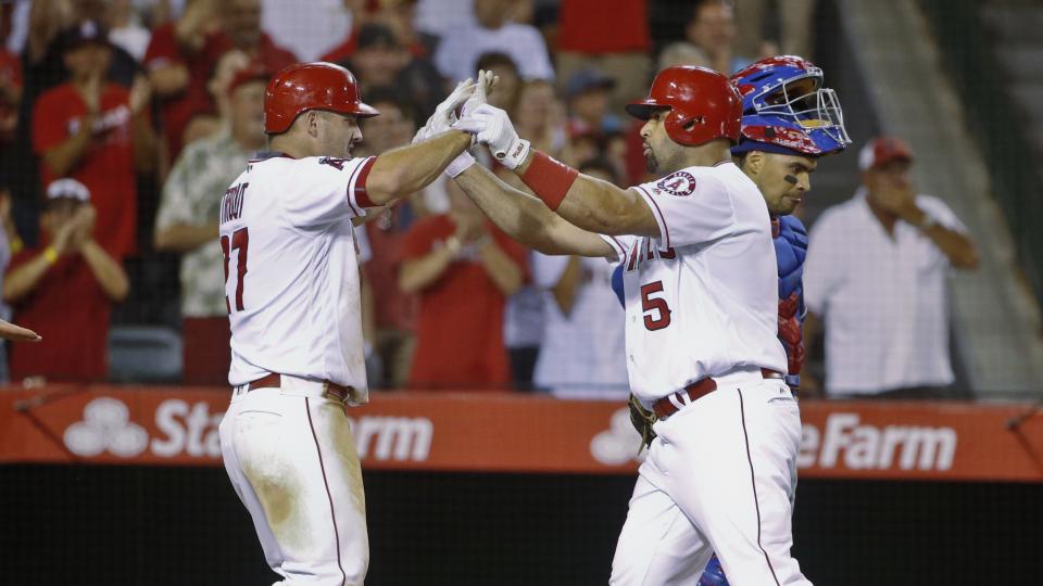 Los Angeles Angels Albert Pujols is congratulated by Mike Trout after hitting his second three run homer against the Texas Rangers in the fifth inning of a baseball game Tuesday