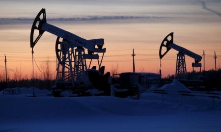 Pump jacks are seen at the Lukoil company owned Imilorskoye oil field as the sun sets outside the West Siberian city of Kogalym Russia