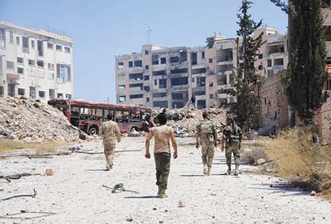 TOPSHOT- Syrian army soldiers patrol the area around the entrance of Bani Zeid after taking control of the previously rebel-held district of Leramun on the northwest outskirts of Aleppo