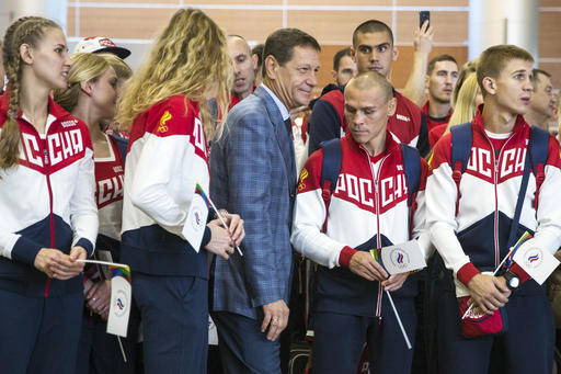 Russian Olympic Committee President Alexander Zhukov center passes through Russia's National Olympic team members during the ceremony before Russian team's departure for Rio Olympics in Moscow's Sheremetyevo Russia Thurs