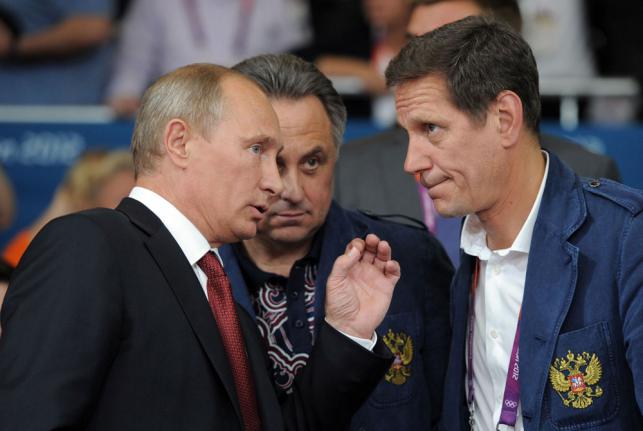 August 2012 shows Russian president Vladimir Putin talking to Russia`s sports minister Vitaly Mutko and Russia`s Olympic committee president Alexander Zhukov after watching the judo competition at the Olympics in Lo