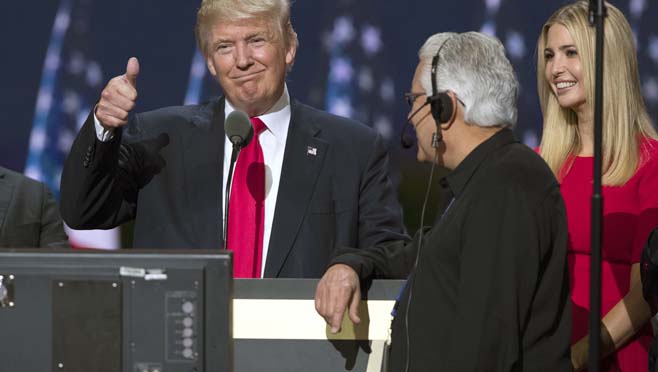 Republican presidential candidate Donald Trump center gives a thumbs up as he talks with production crew during a walk through in preparation for his speech at the Republican National Convention Thursday