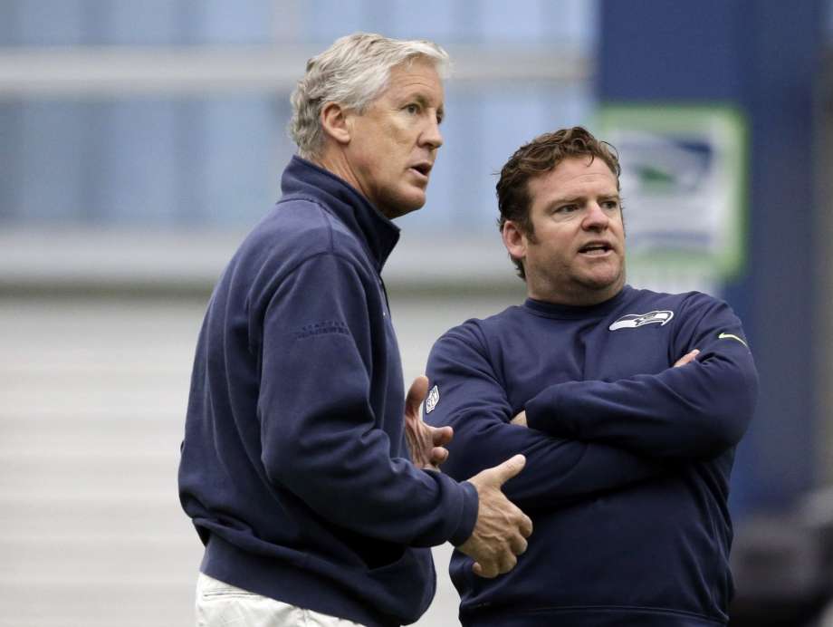 Seattle Seahawks head coach Pete Carroll left and general manager John Schneider talk during an NFL football rookie minicamp workout Sunday