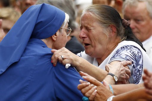 French nun greets a resident during a gathering in a town park for a solemn homage to the Rev. Jacques Hamel in Saint-Etienne-du-Rouvray Normandy France Thursday