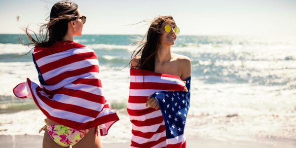 Two women on the beach with American flags