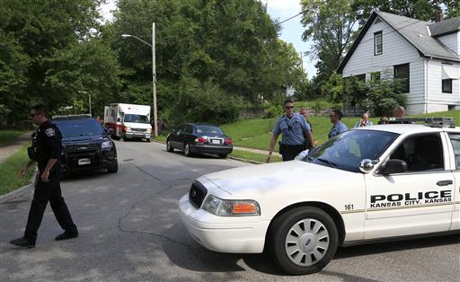 Kansas City Kan. and Shawnee police officers work part of the shooting scene of a police officer in Kansas City Kan. Tuesday