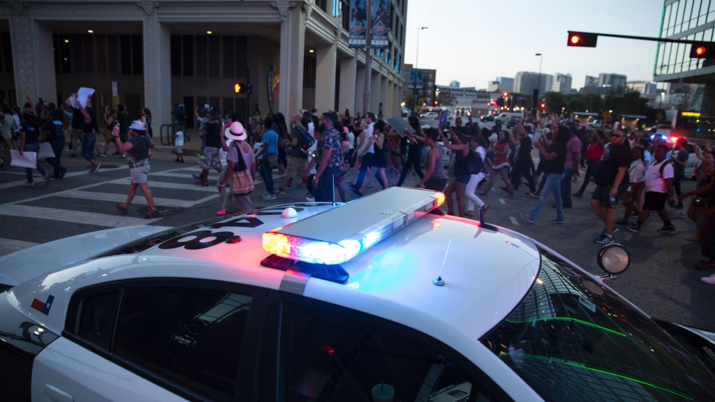 People rally Thursday in Dallas to protest the deaths of Alton Sterling and Philando Castile. A later shootout with what police chief David Brown described as two snipers left at least three police officers dead and at least seven more hurt