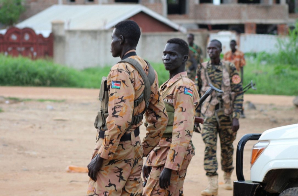 South Sudanese policemen and soldiers stand guard along a street following renewed fighting in South Sudan's capital Juba on Sunday