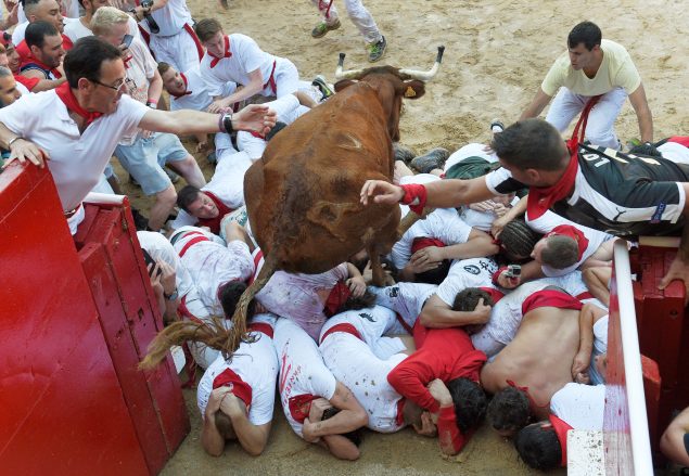 A wild cow jumps over revelers in the bullring after the first running of the bulls at the San Fermin festival in Pamplona northern Spain