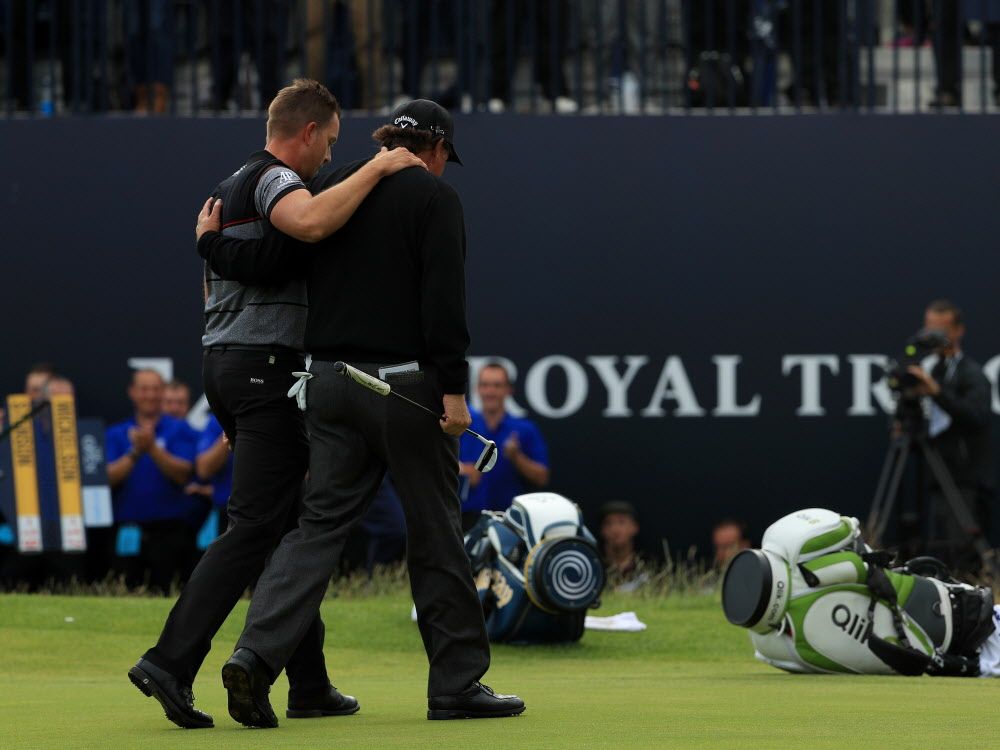 Henrik Stenson of Sweden celebrates victory as he walks off the 18th green with Phil Mickelson of the United States after the final round on day four of the 145th Open Championship at Royal Troon