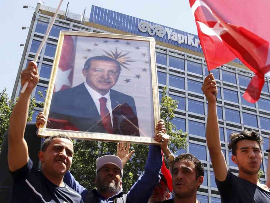 Supporters of Turkish President Tayyip Erdogan lift up his portrait as they celebrate with flags in Ankara Turkey