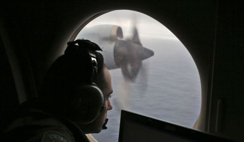 A flight officer aboard a Royal Australian Air Force plane searches for signs of missing Malaysia Airlines Flight MH370 in the southern Indian Ocean off Australia