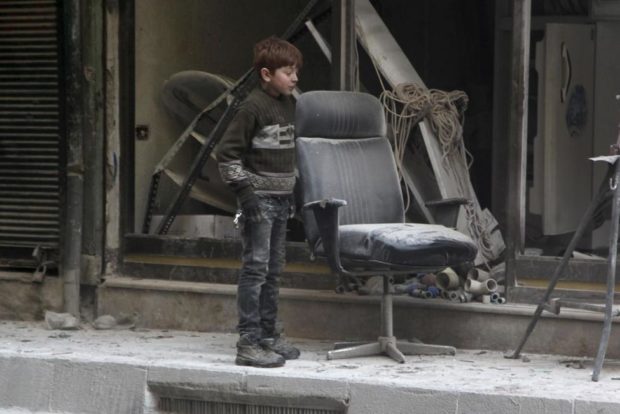 A boy inspects damage after airstrikes by pro Syrian government forces in the rebel held Al Shaar neighborhood of Aleppo Syria