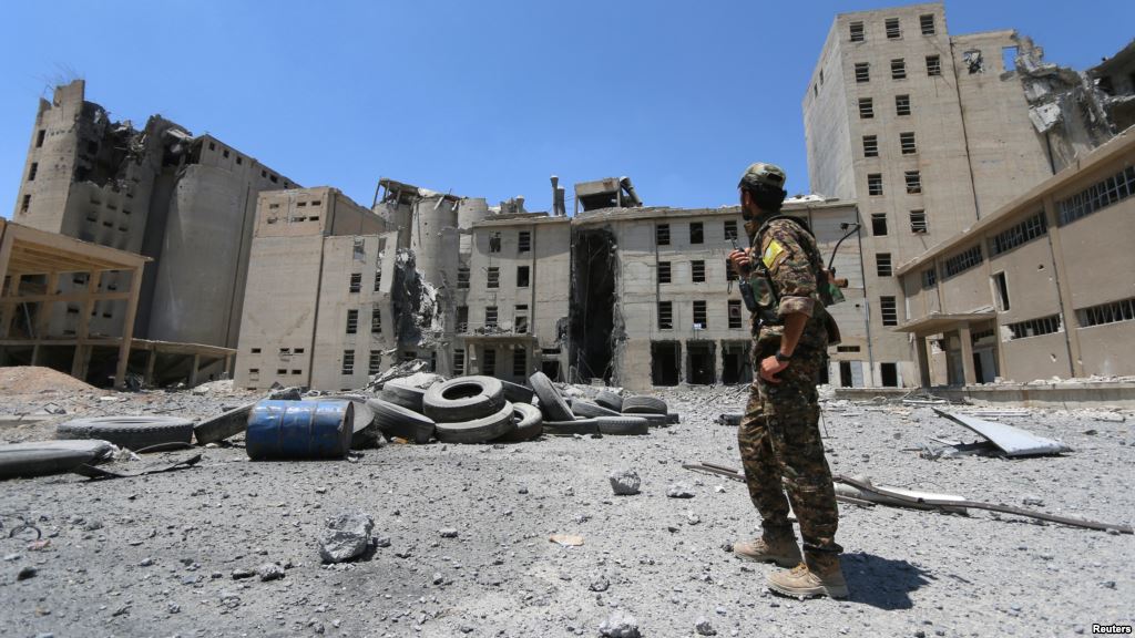 A Syria Democratic Forces fighter walks in the silos and mills of Manbij after the SDF took control of it in Aleppo Governorate Syria