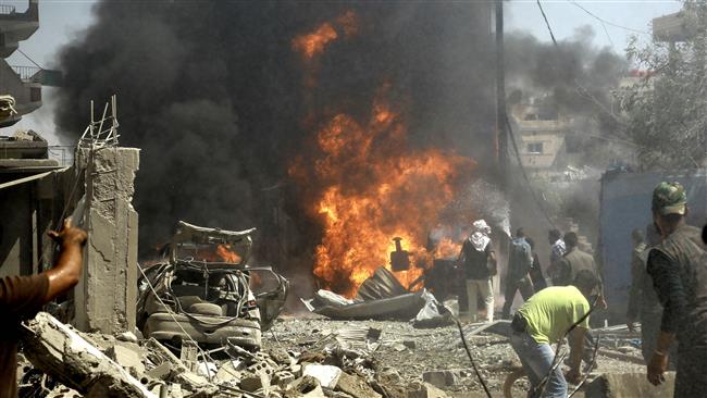 Syrian residents gather at the site of a deadly Daesh bomb attack in the country's northeastern city of Qamishli