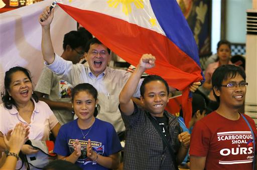 Filipinos applaud moments after the Hague-based U.N. international arbitration tribunal ruled in favor of the Philippines in its case against China on the dispute in South China Sea Tuesday