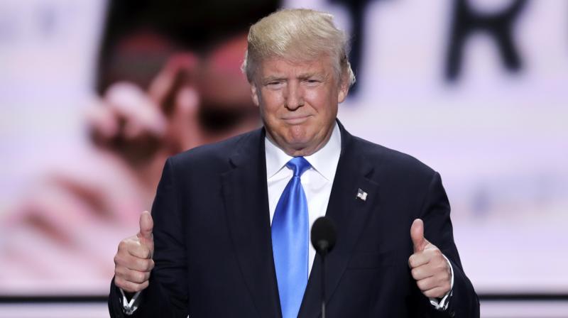 Republican Presidential Candidate Donald Trump flash two thumbs up as he introduces his wife Melania during the opening day of the Republican National Convention in Cleveland