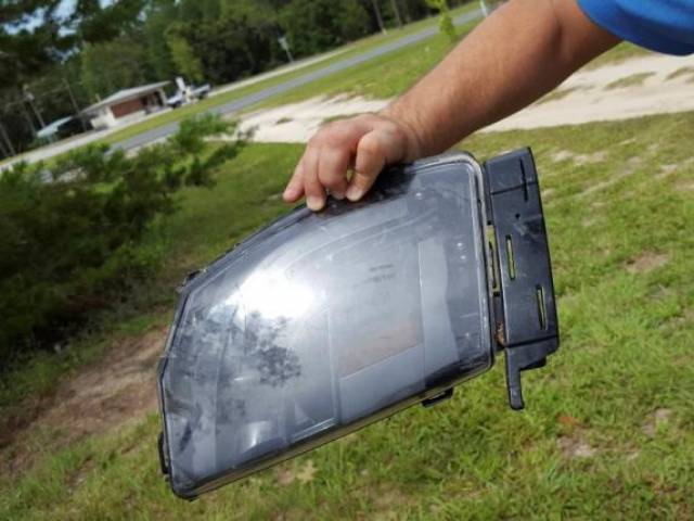 Robert Van Kavelaar shows a piece of the Tesla found in his property where the Tesla came to rest when its driver was killed in a collision with a truck in May in Williston Florida