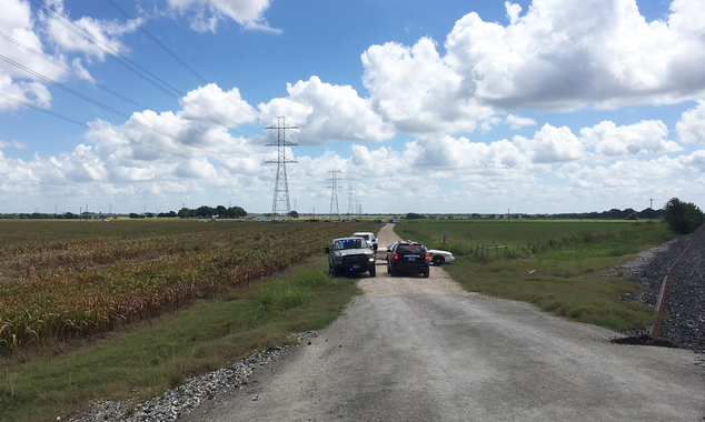 Police cars block access to the site where a hot air balloon crashed early Saturday