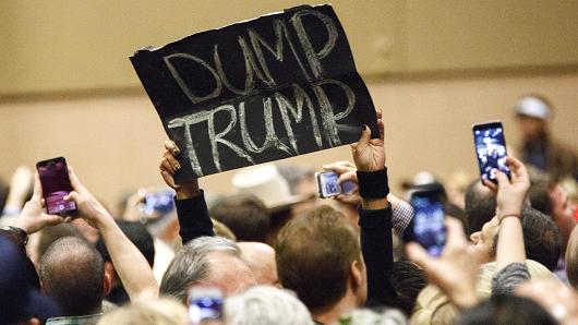 A protester's sign reads 'Dump Trump&#039 during a campaign rally for Donald Trump president and chief executive officer of Trump Organization Inc