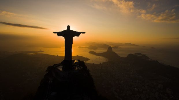 The sun rises behind the Christ the Redeemer statue above the Guanabara bay in Rio de Janeiro