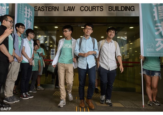 The three Hong Kong student activists leave the courtroom after their conviction for their role in the pro-democracy protests in 2014.- AFP