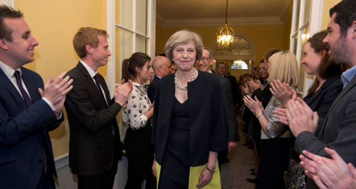 Staff applaud as Britains new Prime Minister Theresa May and her husband Philip walk into 10 Downing Street after May had met Queen Elizabeth in Buckingham Palace in central London Britain