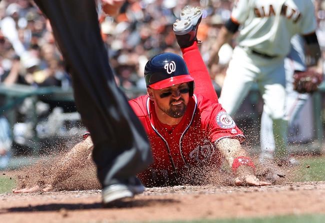 Washington Nationals&#39 Ryan Zimmerman slides into home plate to score a run in front of umpire Chad Fairchild on a Ryan Zimmerman double during the fourth inning of a baseball game against the San Francisco Giants in San Francisco Saturday