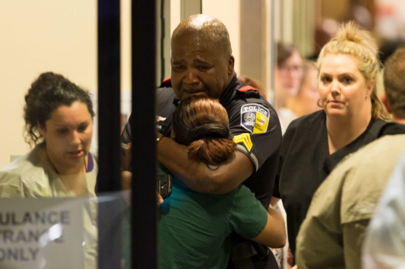 A Dallas Area Rapid Transit police officer receives comfort at the Baylor University Hospital emergency room entrance Thursday in Dallas. Police say one rapid-transit officer has been killed and three injured when gunfire erupted during a protest in downt