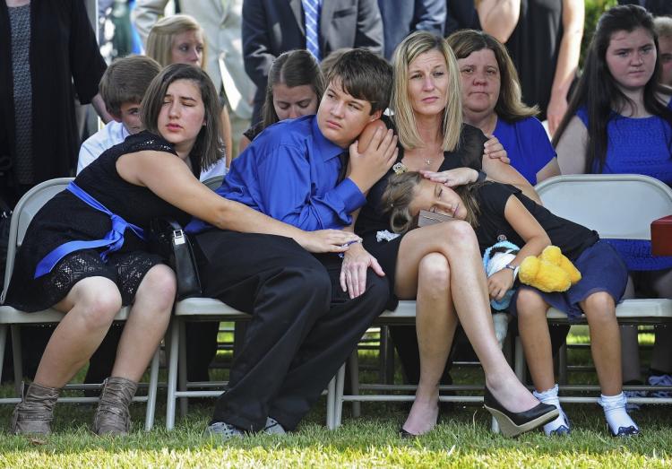 Tonja Garafola the widow of East Baton Rouge Sheriff deputy Brad Garafola mourns with her children during his funeral