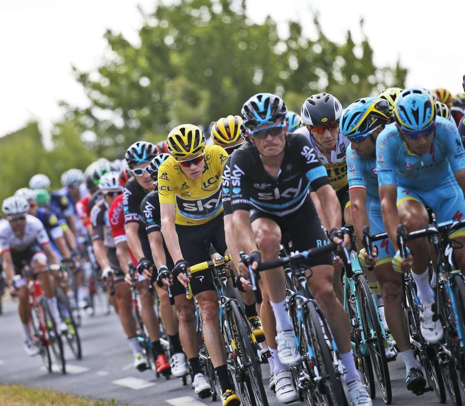 Chris Froome wearing the overall leader’s yellow jersey rides in the pack during the Wednesday’s Stage 11