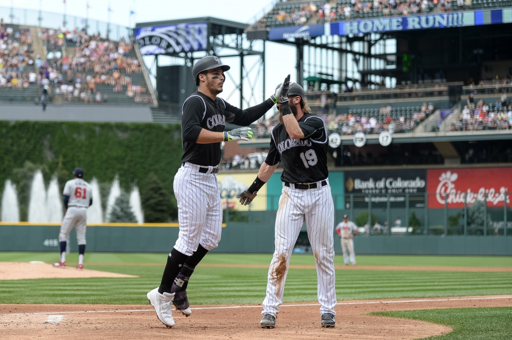 Nolan Arenado #28 of the Colorado Rockies celebrates with Charlie Blackmon #19 after hitting a first inning 3-run home run off of Tyrell Jenkins #61 of the Atlanta Braves during a game at Coors Field