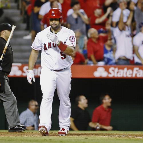 Angels&#039 Albert Pujols slings his bat away after launching his three-run home run against the Texas Rangers in the fifth inning of a baseball game Tuesday