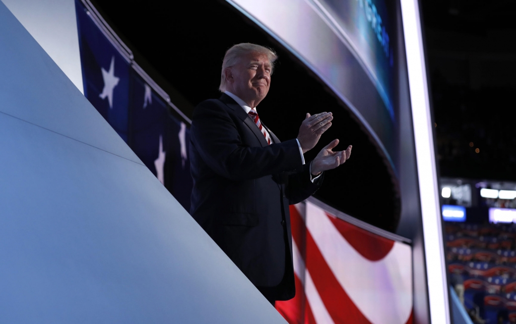 Republican US presidential nominee Donald Trump applauds onstage as his running mate Indiana Governor Mike Pence concludes his speech during the third night of the Republican National Convention in Cleveland Ohio