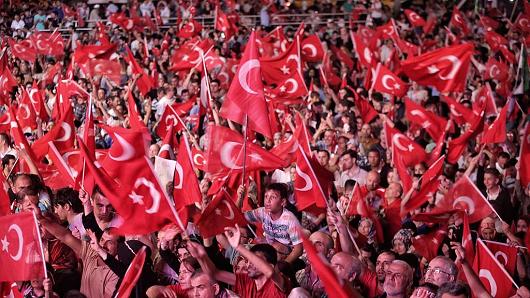 Supporters of Turkish President Tayyip Erdogan wave Turkish flags as they gather in Istanbul's central Taksim Square