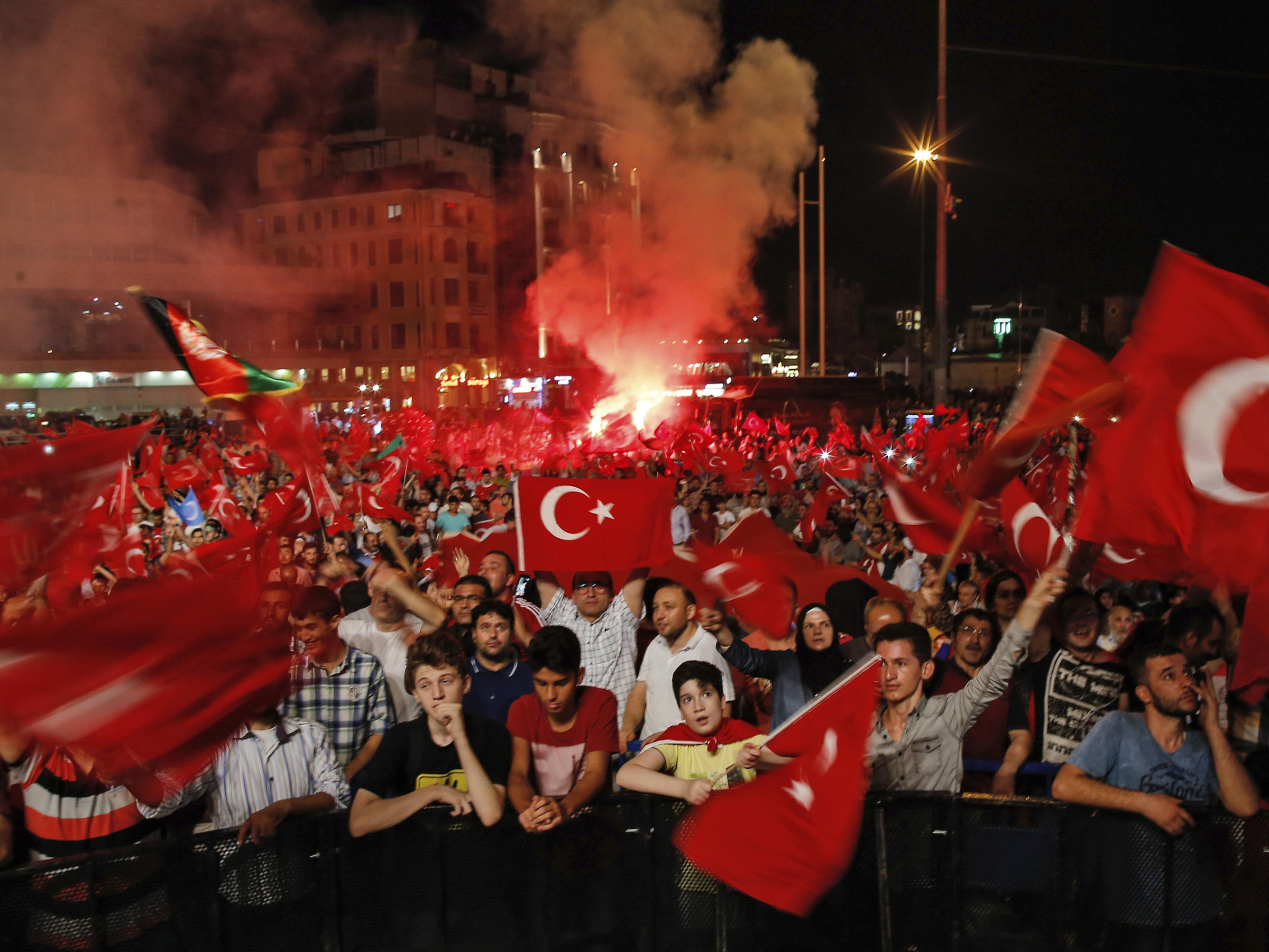 People wave Turkish flags Tuesday as they gather in Taksim Square in Istanbul protesting against the attempted coup last Friday. The Turkish government accelerated its crackdown on alleged plotters of the failed coup against President Recep Tayyip Erdoga