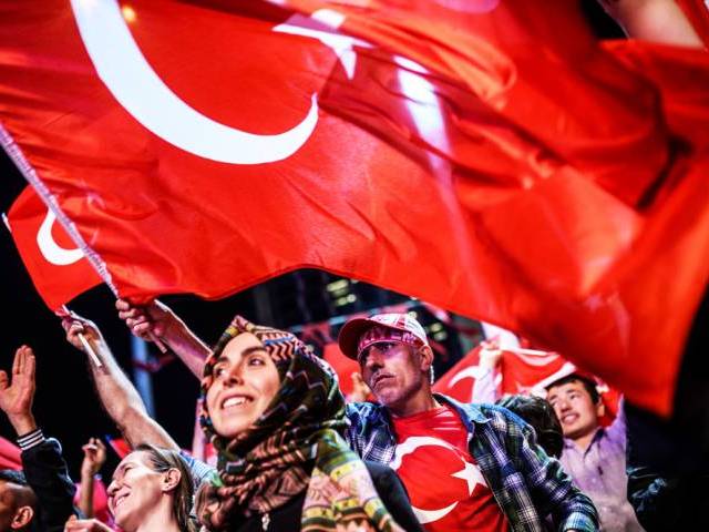 Pro-Erdogan supporters wave Turkish national flags during a rally in Taksim square in Istanbul